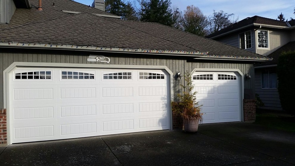 Cette image montre un grand garage pour trois voitures attenant traditionnel.