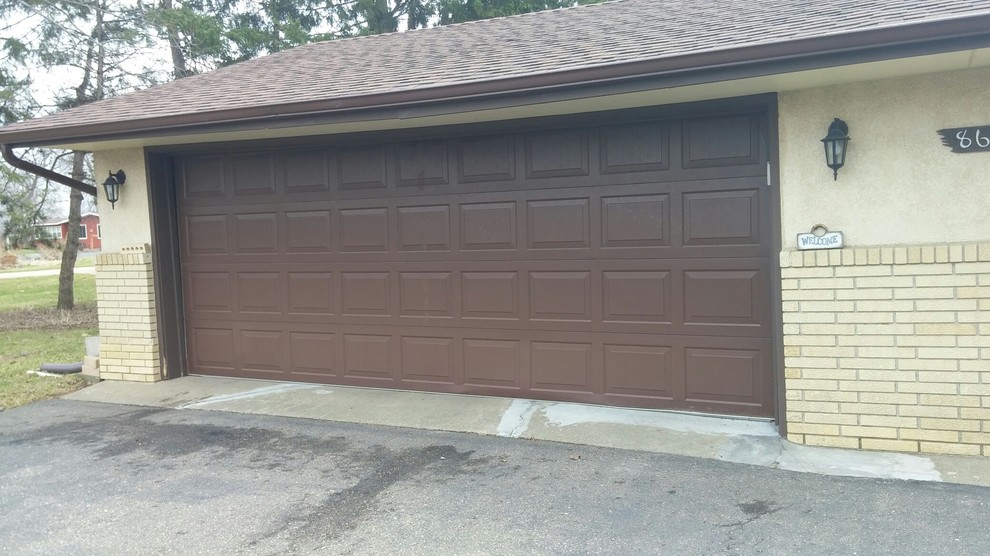Cette photo montre un grand garage pour deux voitures attenant chic.