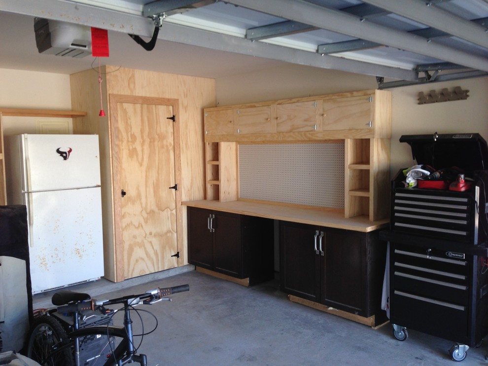 This is an example of a medium sized traditional attached double garage workshop in Houston.