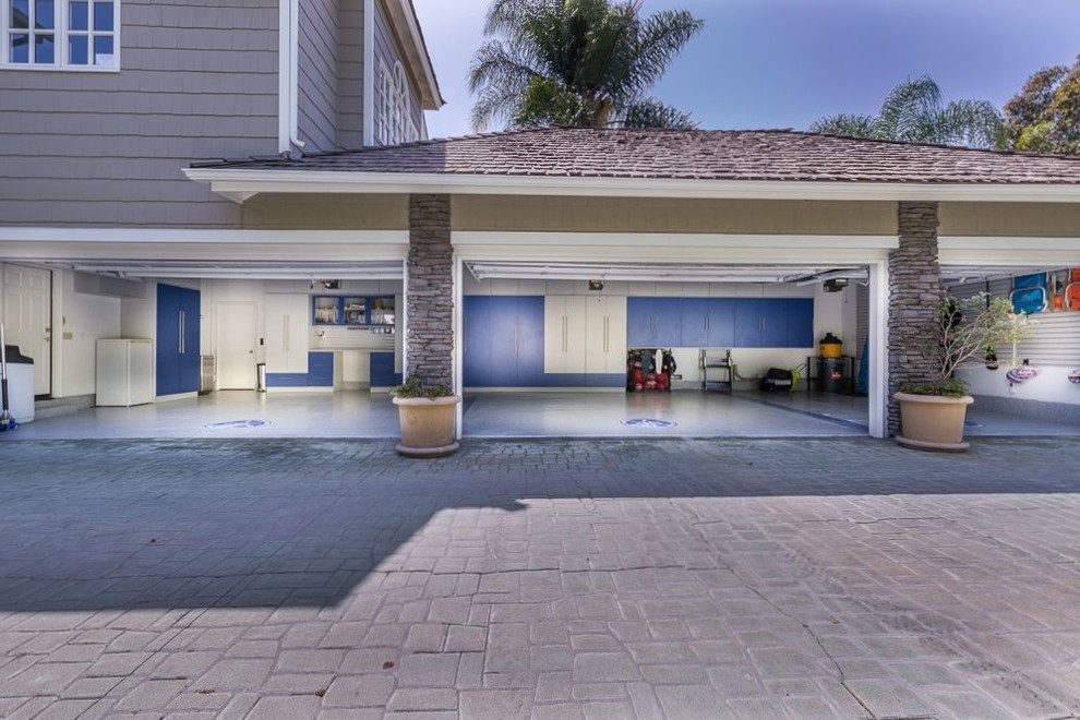 Cette image montre un très grand garage pour trois voitures attenant minimaliste.