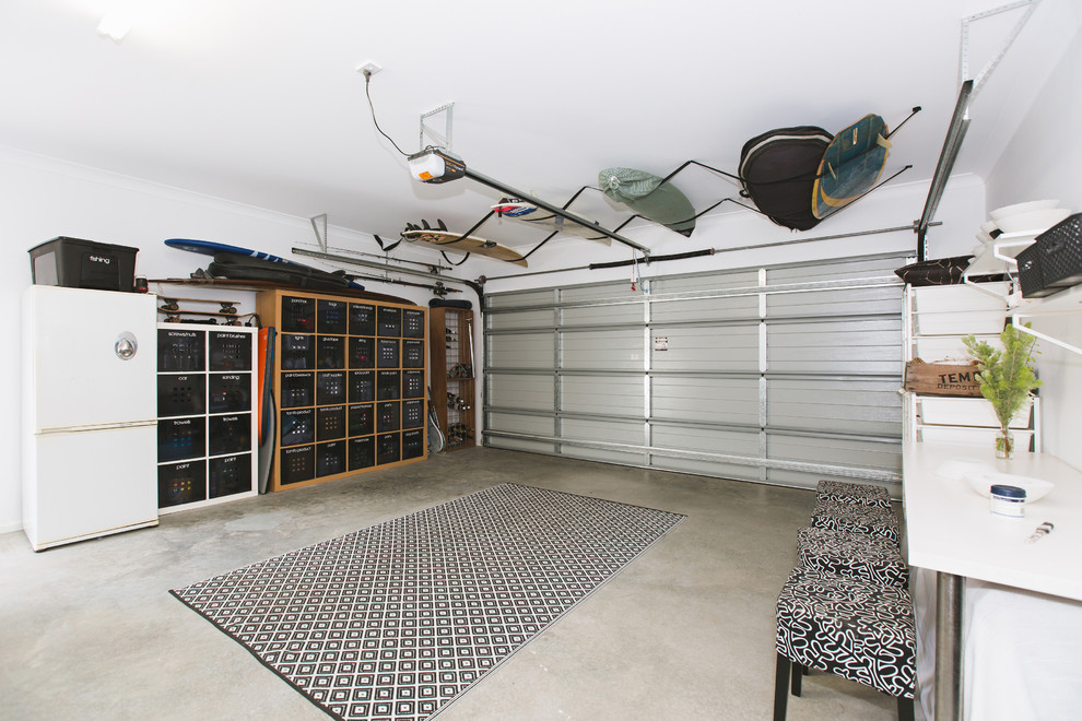 Exemple d'un garage pour deux voitures attenant moderne avec un bureau, studio ou atelier.