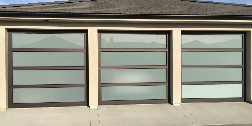 Design ideas for a large modern attached garage in Los Angeles with three or more cars.