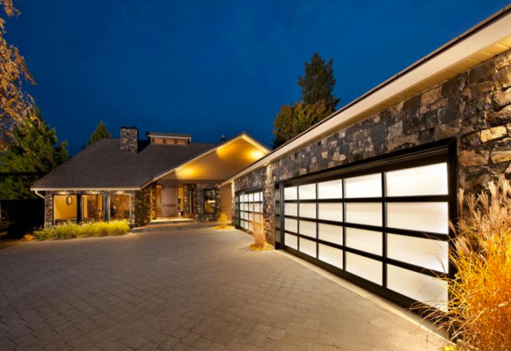Garage - large contemporary attached three-car garage idea in Calgary