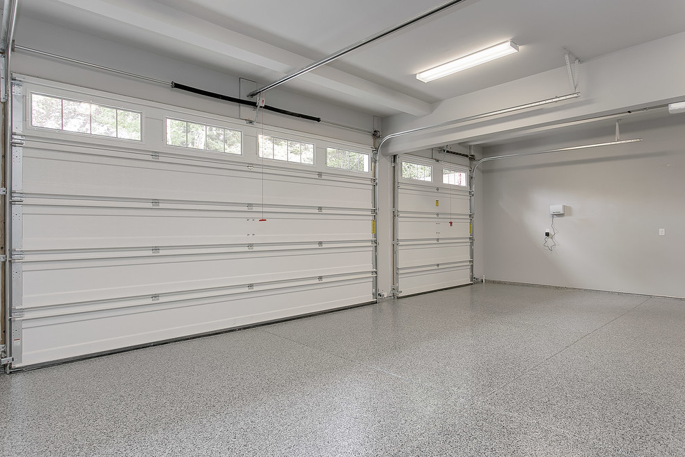 На фото: большой пристроенный гараж в стиле неоклассика (современная классика) для трех машин с