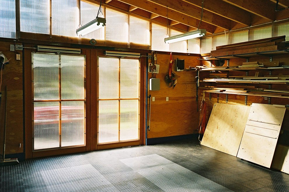 Пример оригинального дизайна: большой отдельно стоящий гараж в стиле модернизм с мастерской для одной машины