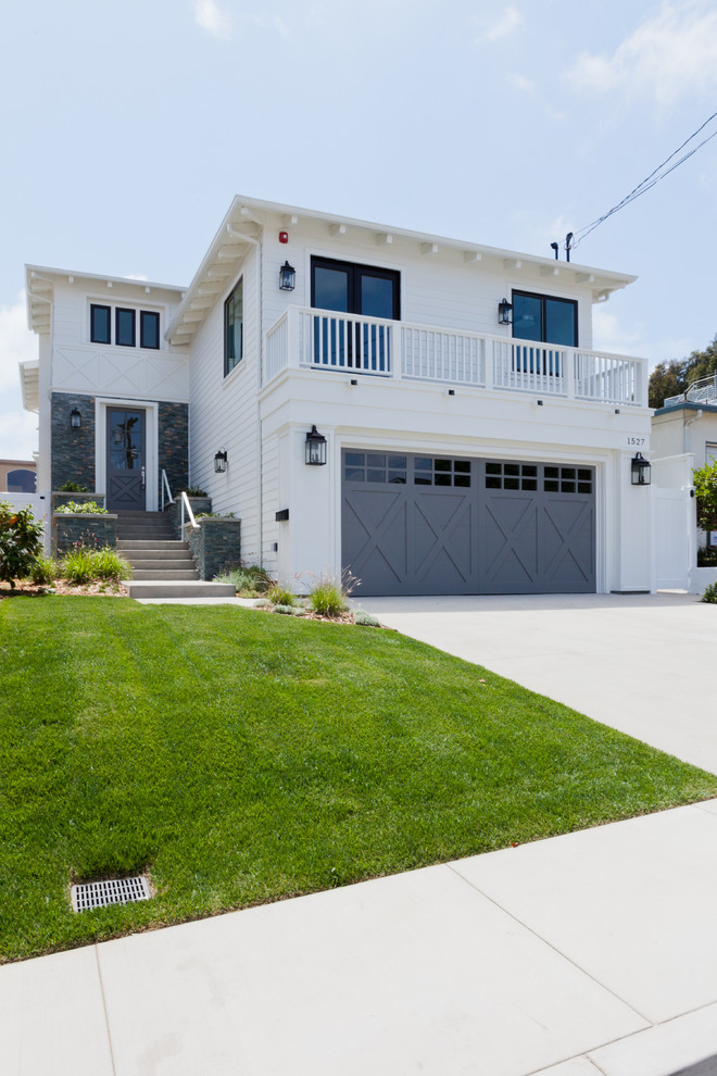 Example of a large beach style attached two-car garage design in Los Angeles