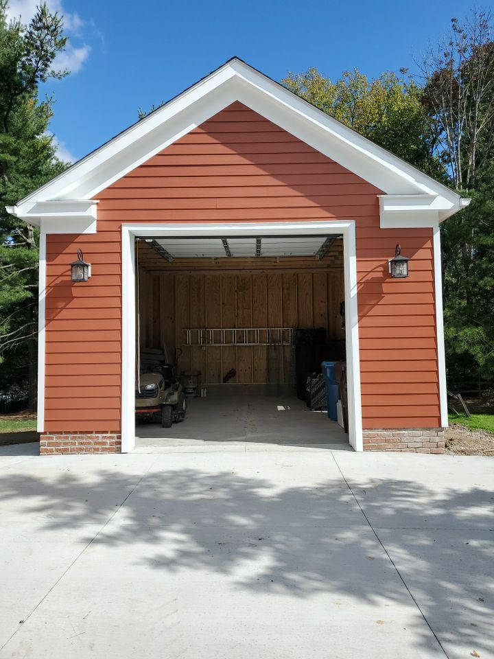 На фото: маленький отдельно стоящий гараж с мастерской для на участке и в саду, одной машины
