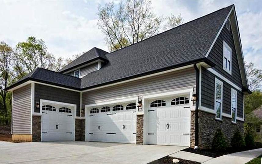 На фото: большой пристроенный гараж в стиле кантри для четырех и более машин