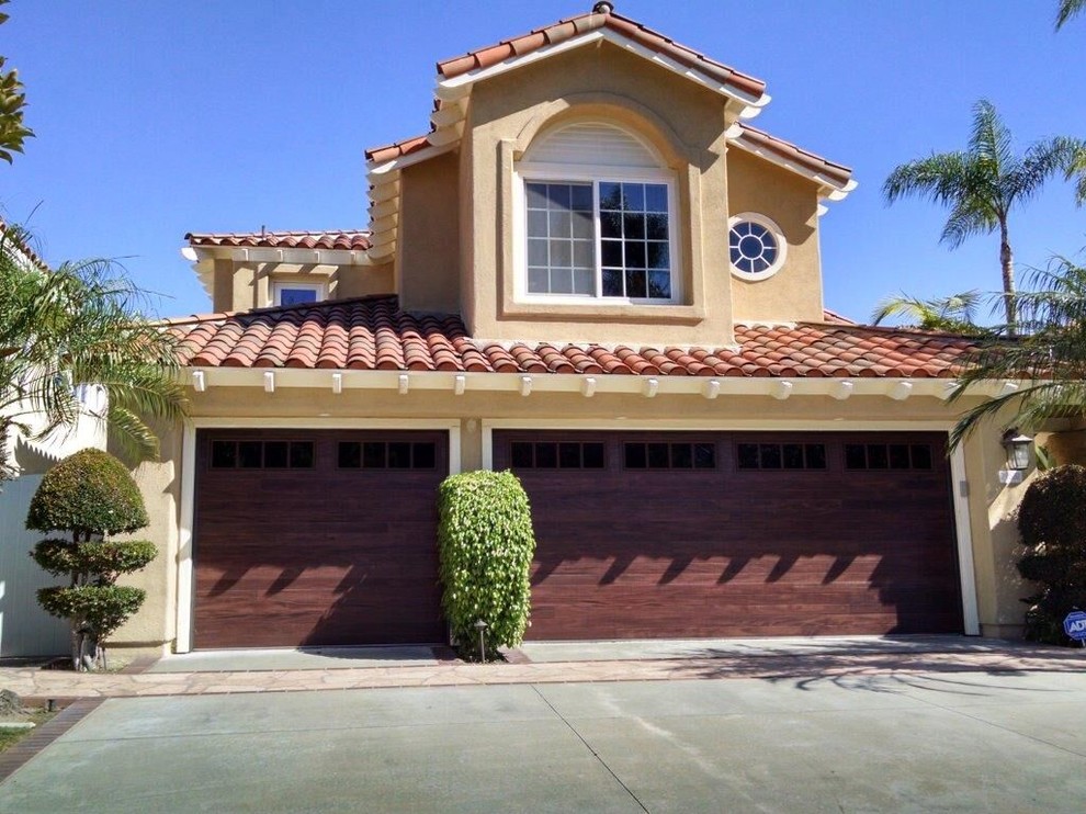 Large beach style attached three-car garage photo in Orange County