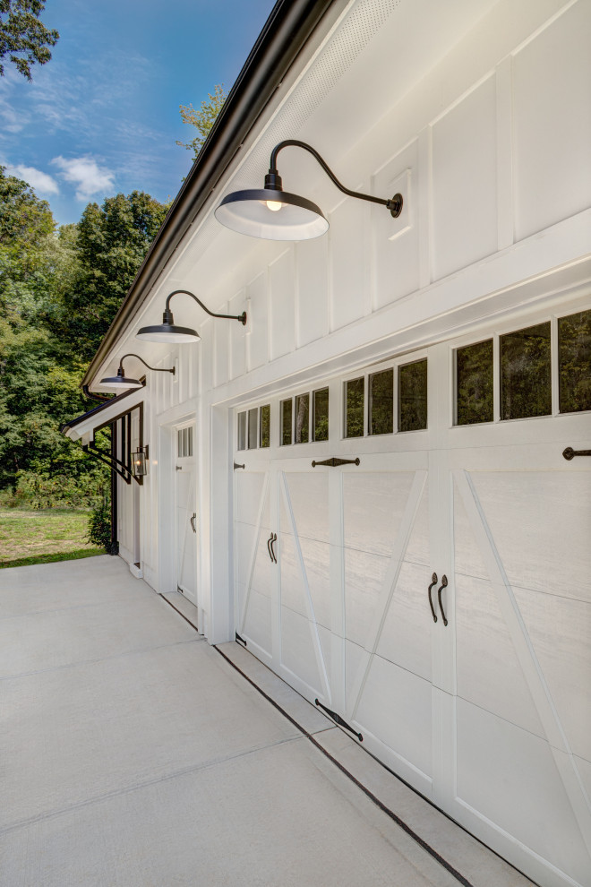 Example of a farmhouse attached three-car garage design in Charlotte