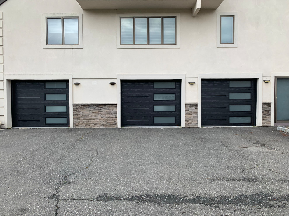 Inspiration pour un grand garage pour trois voitures attenant minimaliste.
