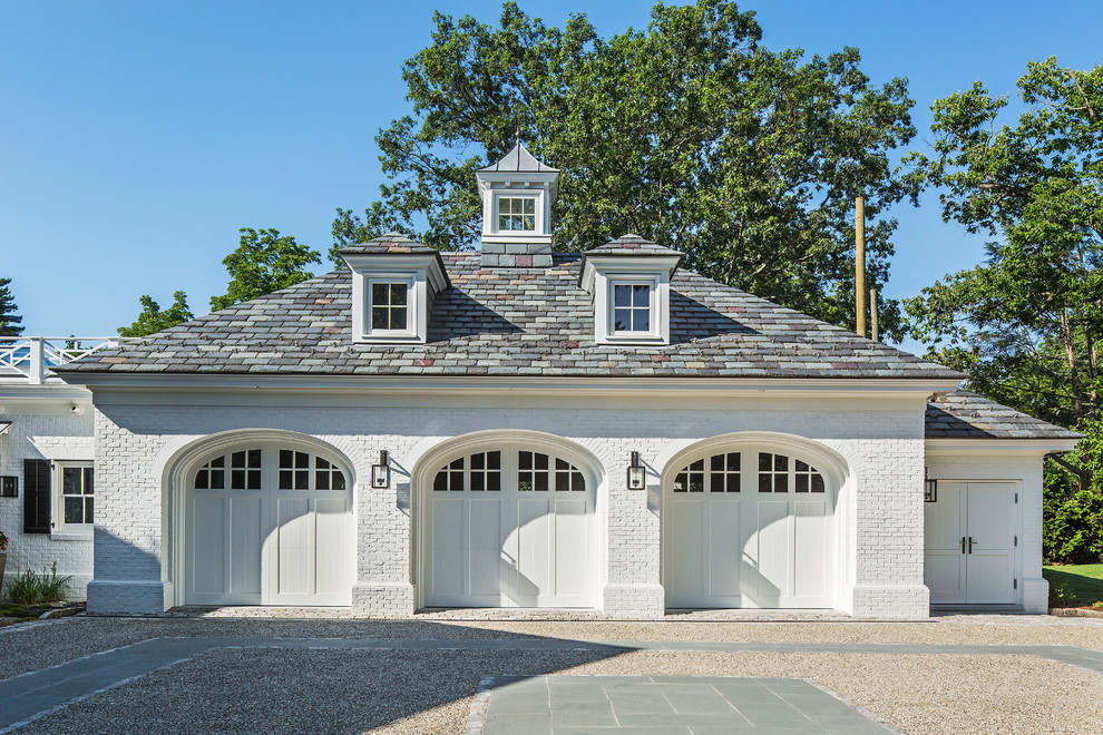 Large transitional attached three-car garage photo in New York