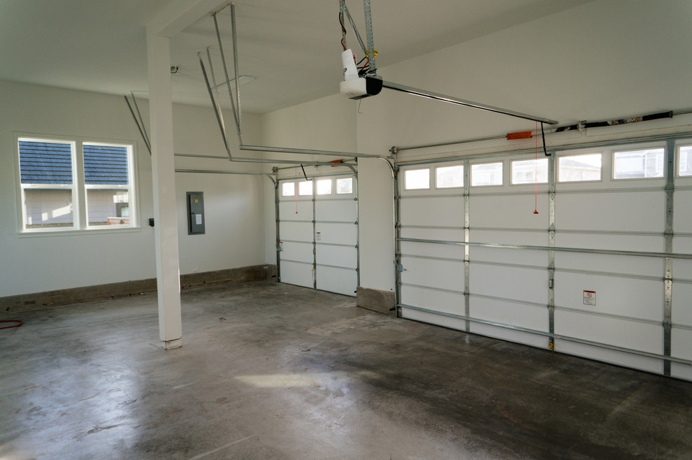 Garage - large traditional attached three-car garage idea in Portland