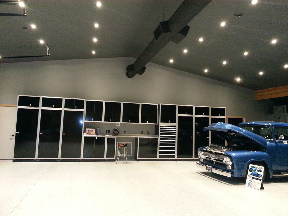 На фото: огромный отдельно стоящий гараж в стиле модернизм для трех машин с