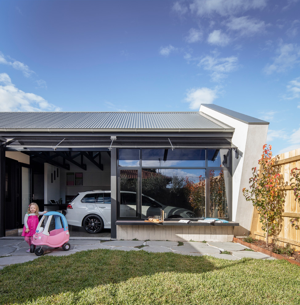 На фото: пристроенный гараж среднего размера в современном стиле с навесом для автомобилей для двух машин с