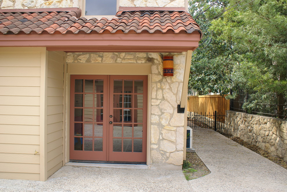 This is an example of a medium sized mediterranean attached double carport in Austin.