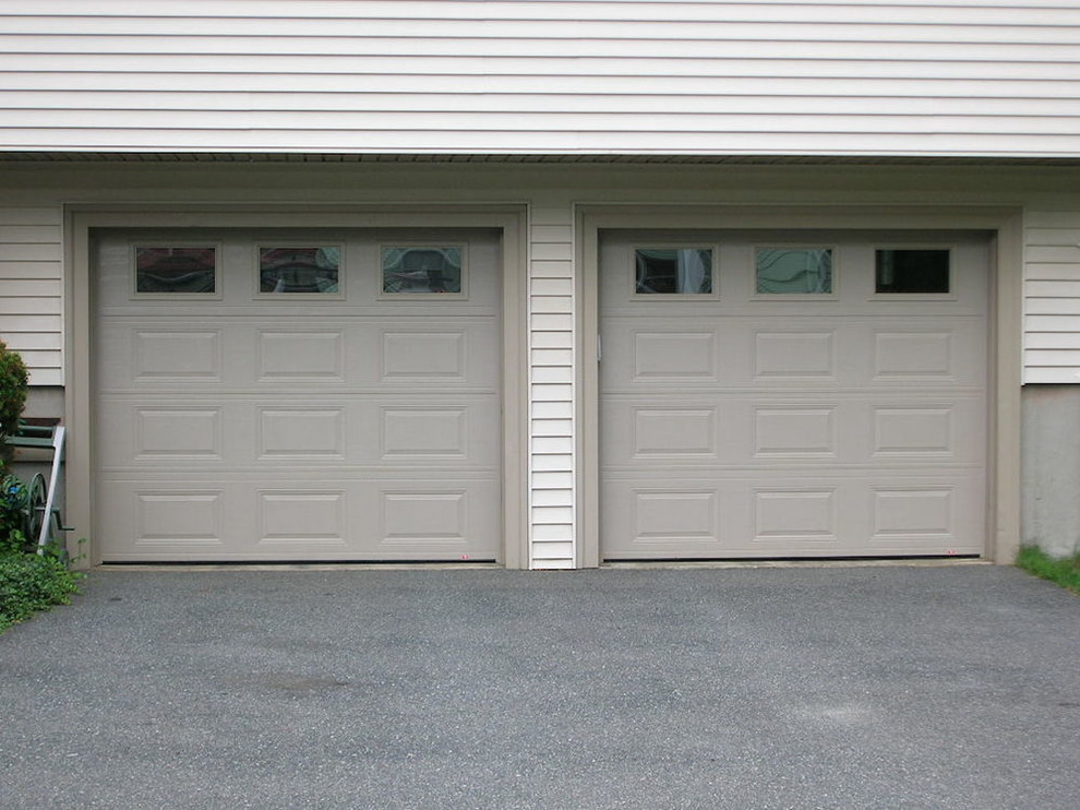 На фото: пристроенный гараж среднего размера в стиле неоклассика (современная классика) для двух машин с