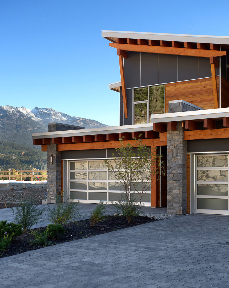 Aménagement d'un garage pour trois voitures attenant contemporain.