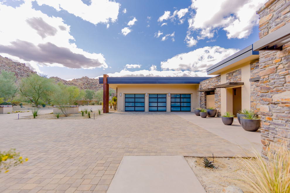 This is an example of an expansive contemporary attached garage in Other with three or more cars.