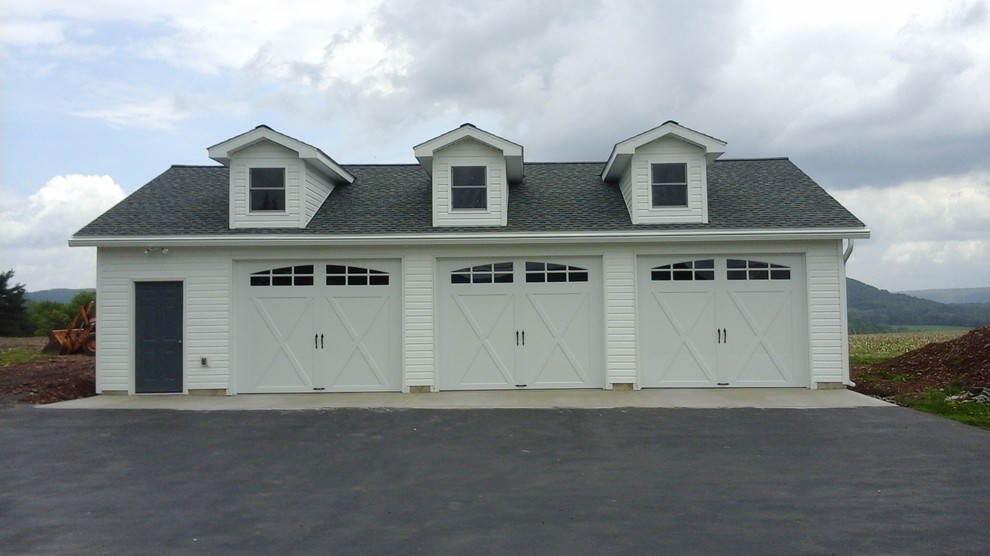 Example of a large cottage detached three-car garage design in Philadelphia