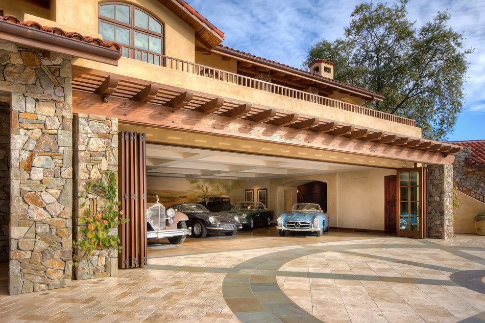 На фото: пристроенный гараж в средиземноморском стиле для четырех и более машин