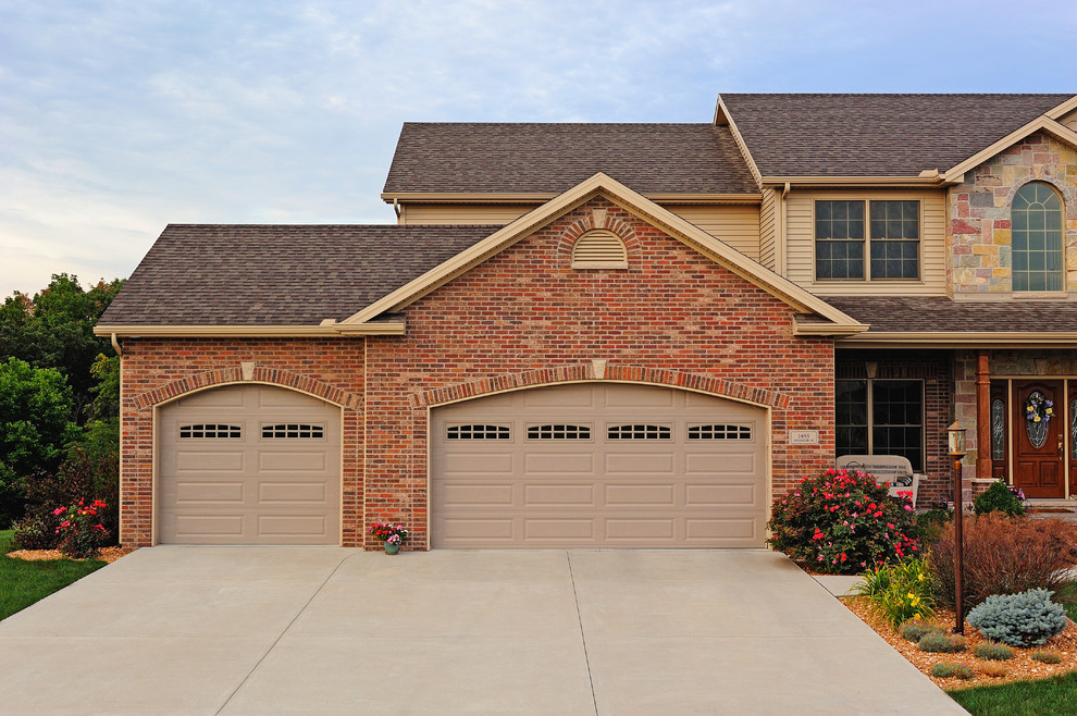 Example of a large classic attached two-car garage design in Other