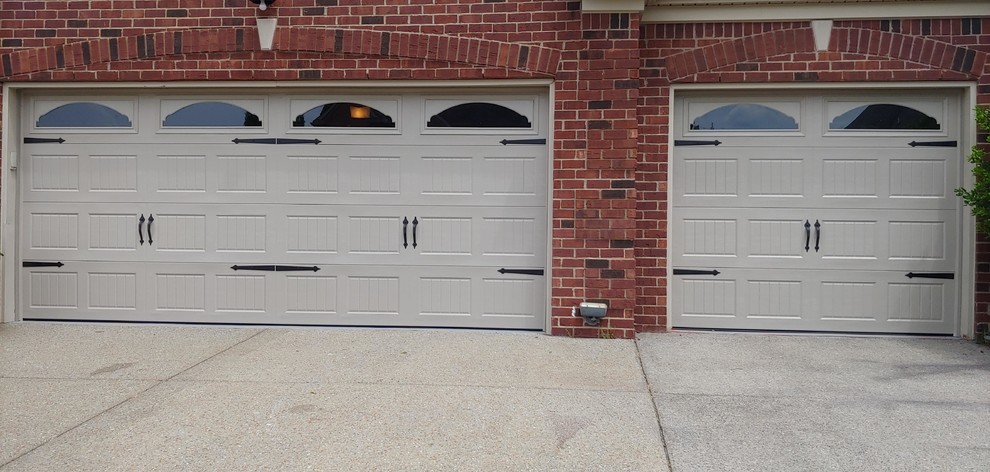 Garage - large traditional attached three-car garage idea in St Louis