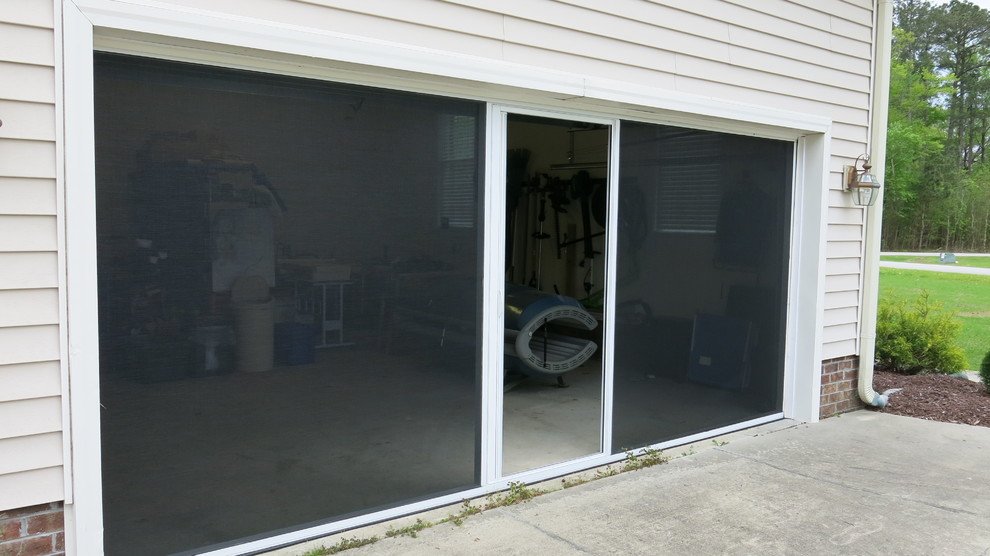 Cette image montre un garage pour deux voitures attenant design de taille moyenne avec un bureau, studio ou atelier.