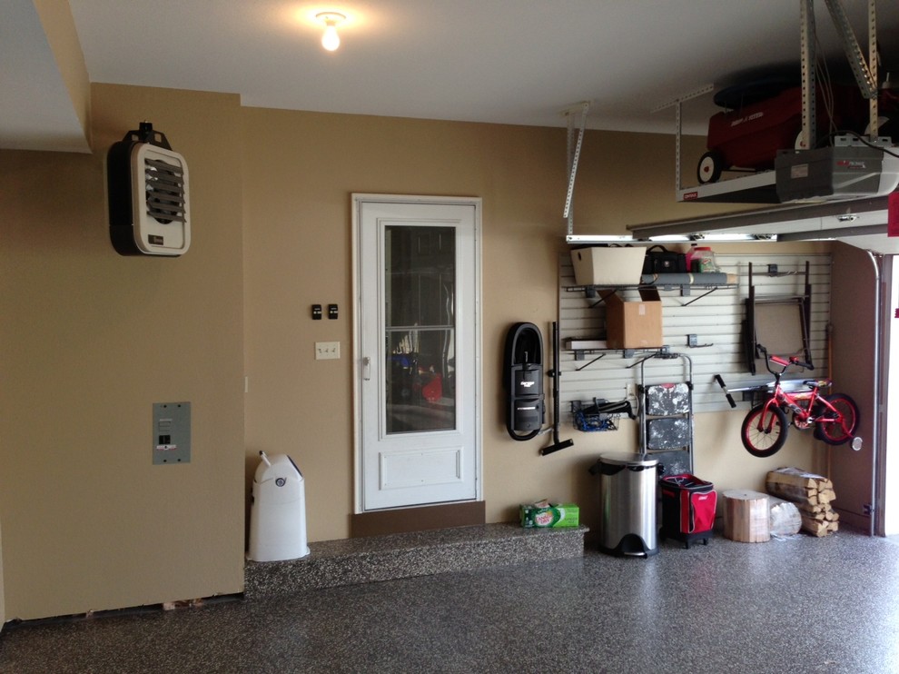 Example of a mid-sized classic attached three-car garage design in Other