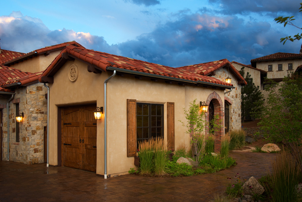 Example of a large tuscan attached garage design in Denver