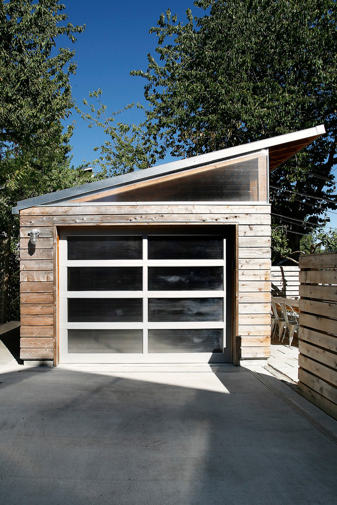 На фото: отдельно стоящий гараж среднего размера в современном стиле для одной машины с