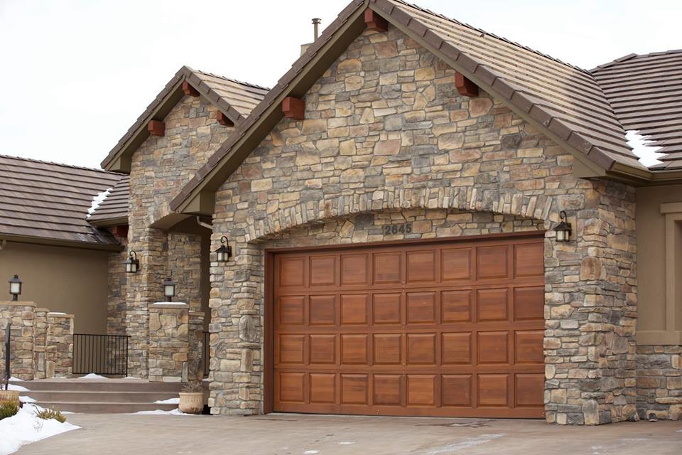Пример оригинального дизайна: большой пристроенный гараж в стиле рустика с навесом для автомобилей для двух машин
