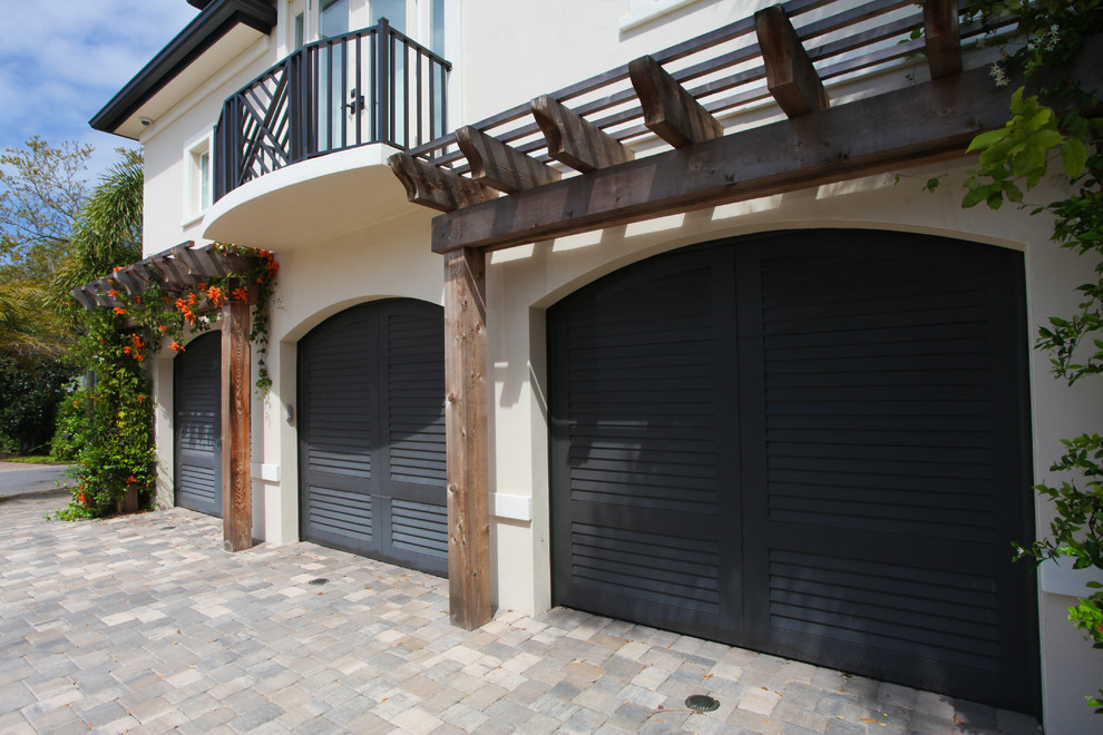 Cette image montre un grand garage pour trois voitures attenant traditionnel.