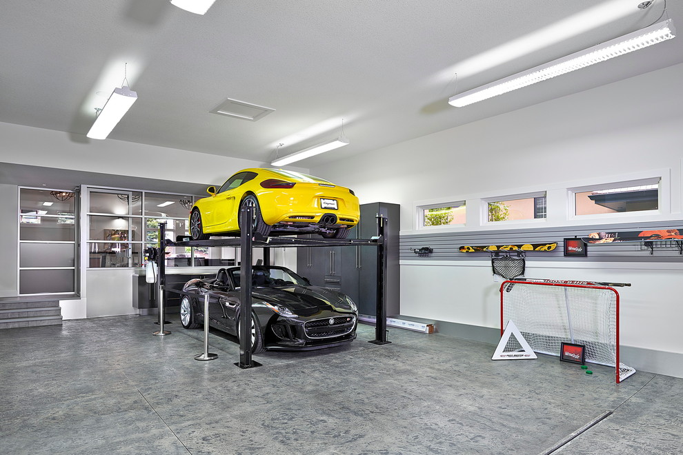 Idée de décoration pour un grand garage pour trois voitures attenant design avec un bureau, studio ou atelier.