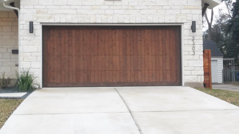 Idée de décoration pour un garage pour deux voitures attenant minimaliste de taille moyenne avec une porte cochère.