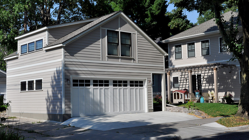 На фото: большой отдельно стоящий гараж в стиле неоклассика (современная классика) с мастерской для двух машин с