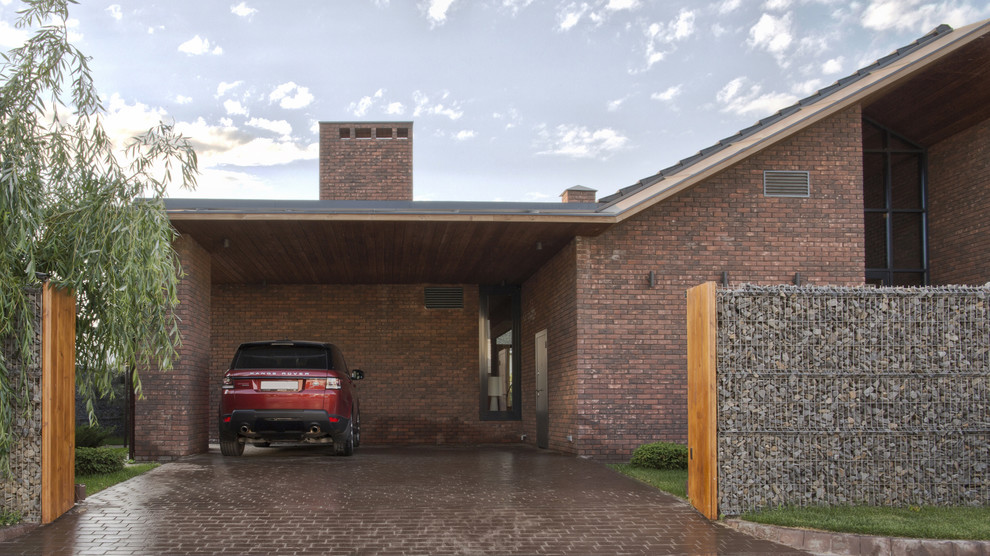 На фото: пристроенный гараж среднего размера в современном стиле для двух машин с