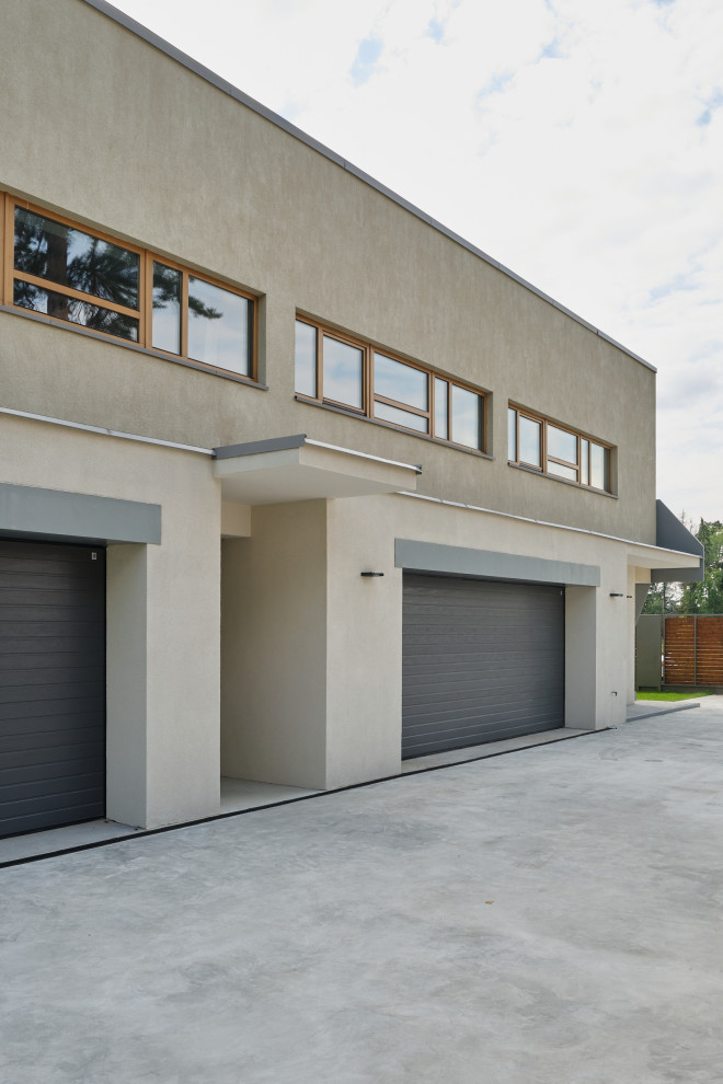 Cette photo montre un grand garage pour quatre voitures ou plus attenant moderne.