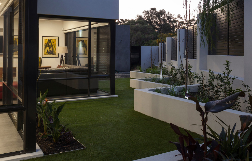 Cette photo montre un jardin latéral moderne de taille moyenne avec un mur de soutènement, une exposition partiellement ombragée et du gravier.