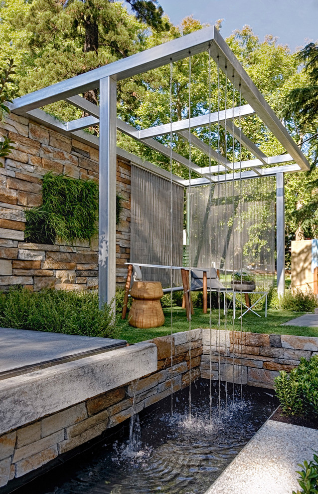 Design ideas for a contemporary garden in Melbourne with a water feature.