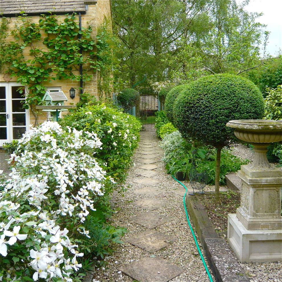 Geometrischer, Halbschattiger Shabby-Chic Garten im Sommer, hinter dem Haus mit Natursteinplatten in Oxfordshire