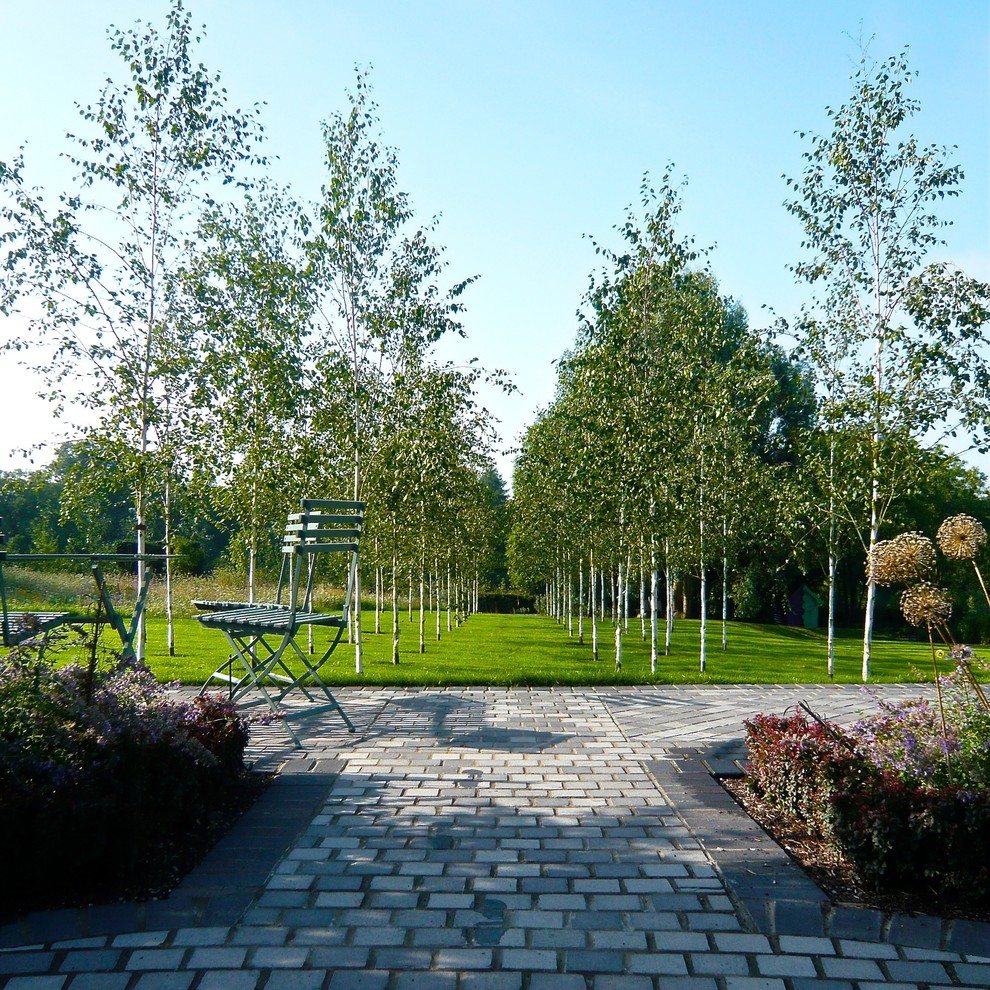 Esempio di un ampio giardino country esposto in pieno sole dietro casa con pavimentazioni in pietra naturale