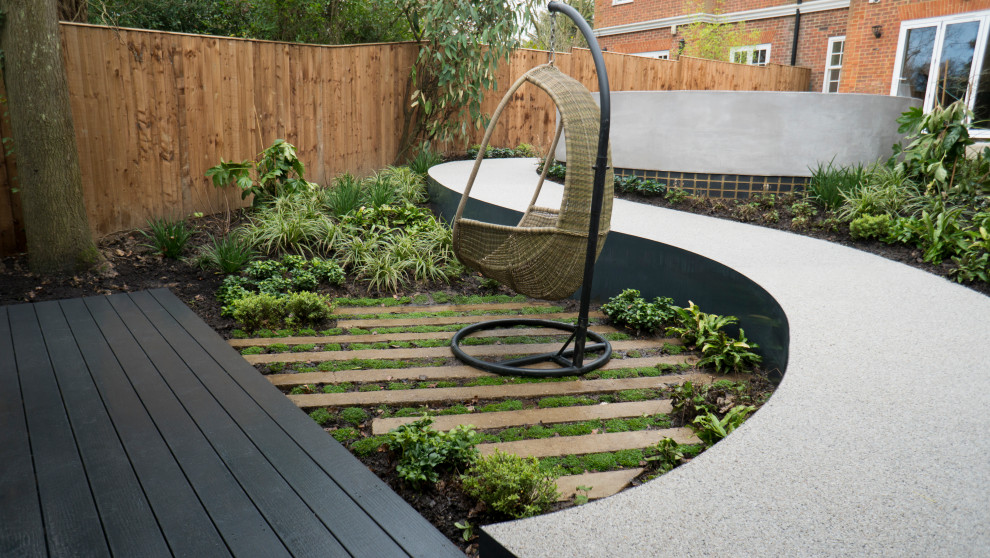 Photo of a medium sized contemporary back partial sun garden for summer in London with a pathway and decking.