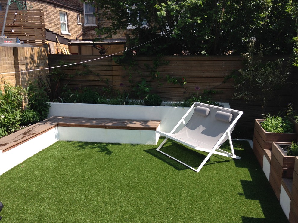 Design ideas for a small modern full sun backyard formal garden in London with decking for summer.