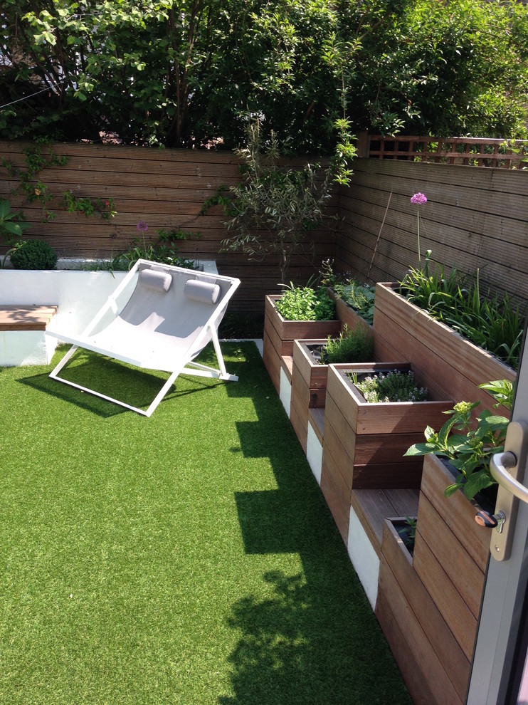 Inspiration för små moderna trädgårdar i full sol på sommaren, med utekrukor och trädäck