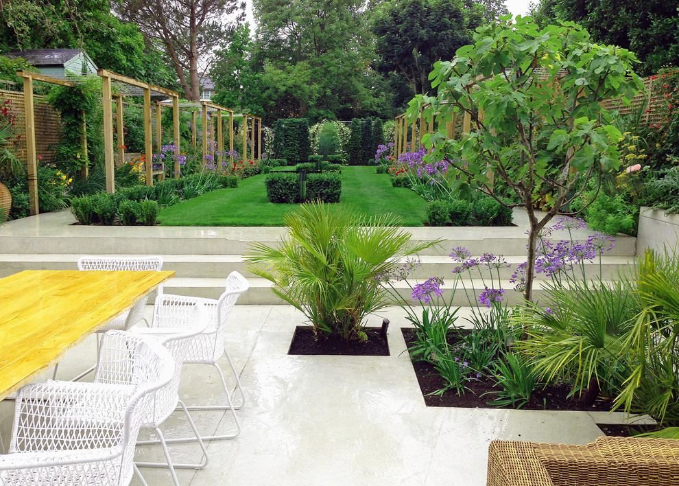 На фото: большой солнечный, летний регулярный сад на заднем дворе в современном стиле с хорошей освещенностью