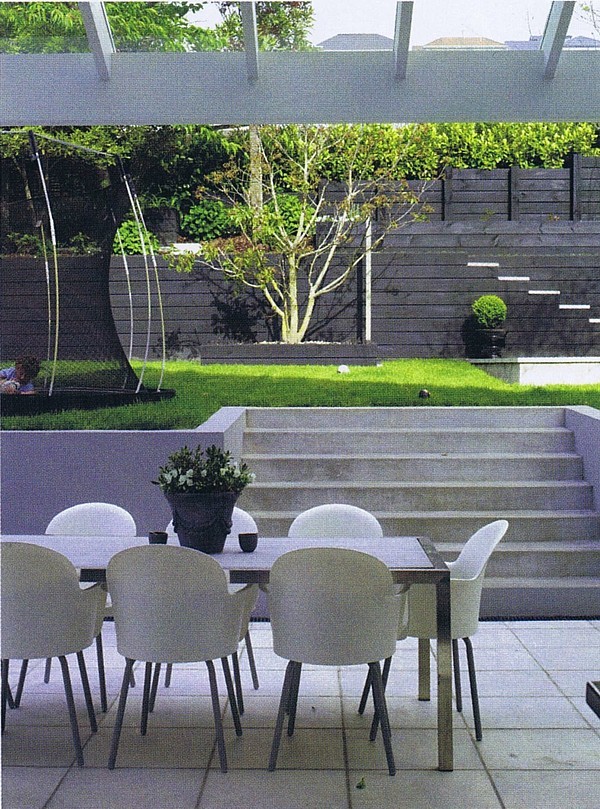 Idée de décoration pour un grand jardin à la française arrière avec un mur de soutènement et des pavés en béton.