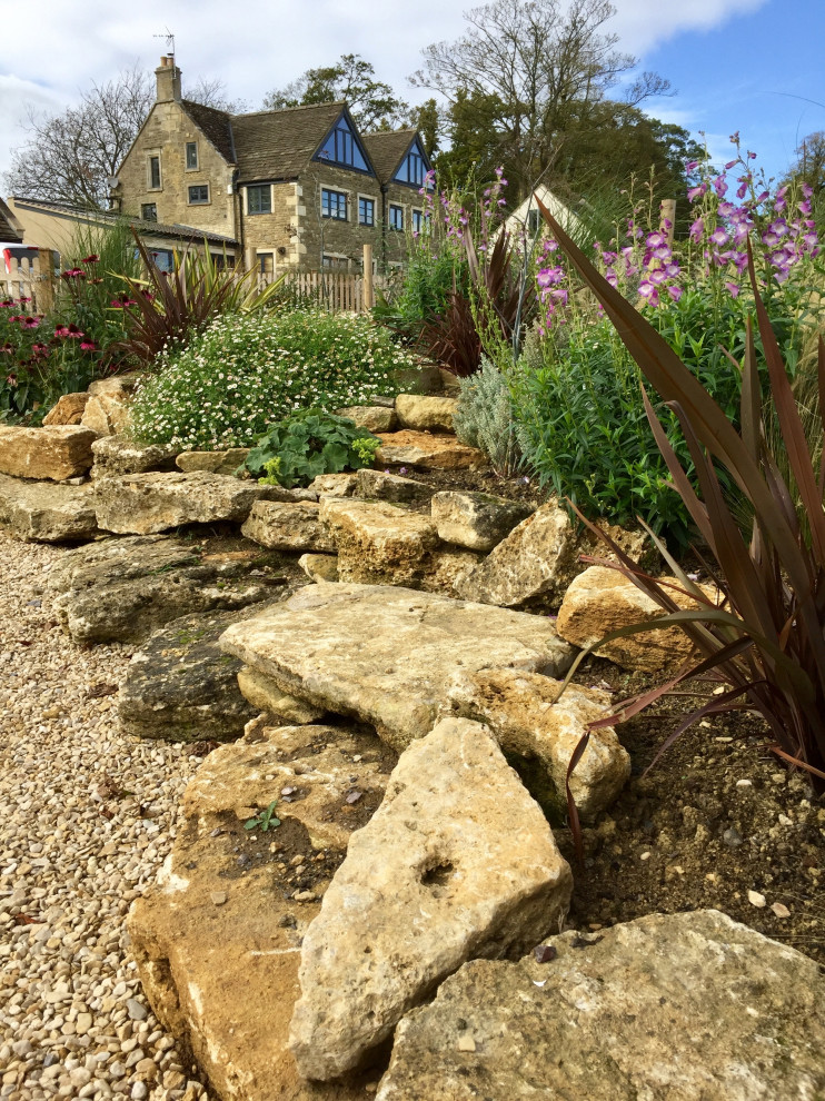 This is an example of a large contemporary sloped full sun garden for summer in Other with a rockery and gravel.
