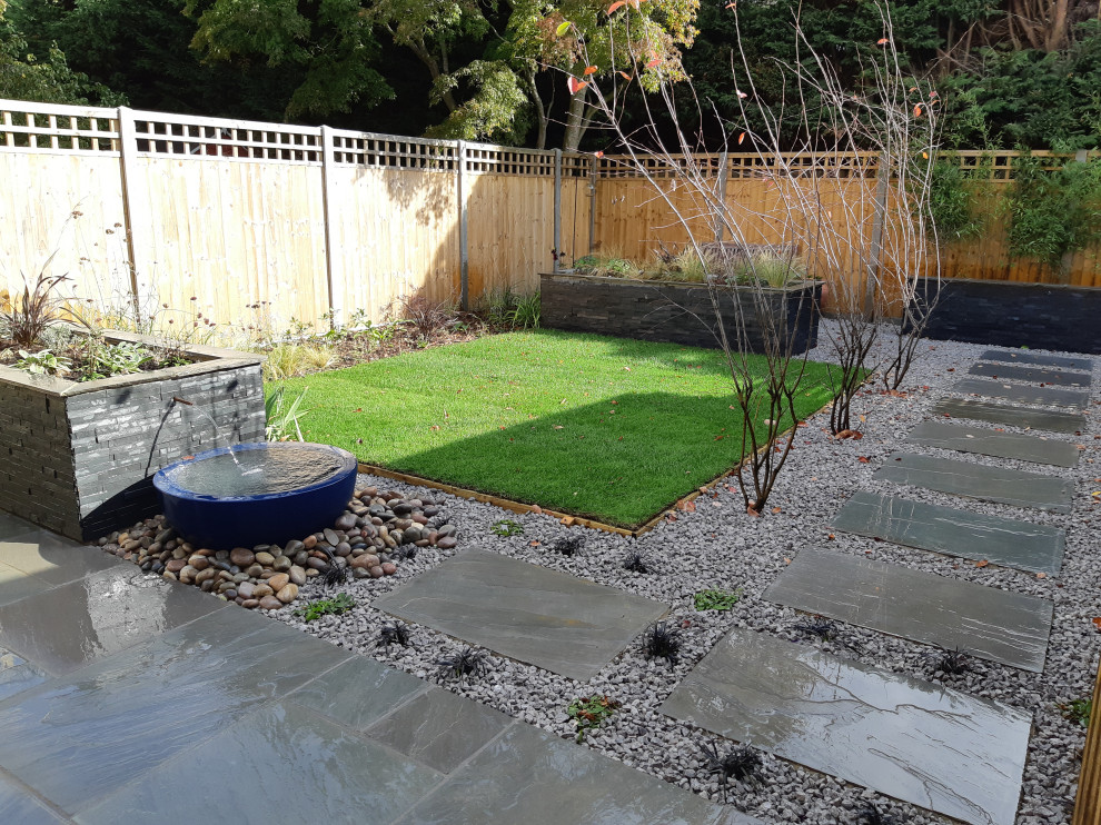 Inspiration pour un petit jardin arrière design avec une exposition ensoleillée et des pavés en pierre naturelle.