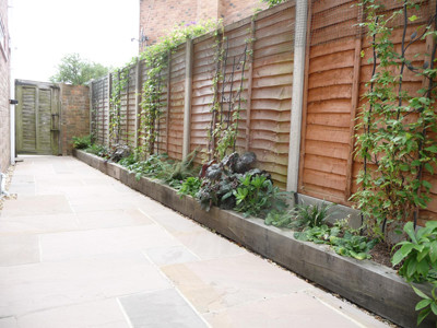 Photo of a large modern shade side yard stone landscaping in Sussex for spring.